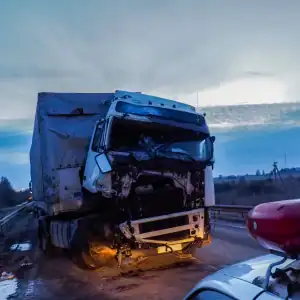 Damaged commercial truck after a highway accident, with police presence at the scene
